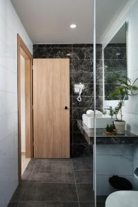 La salle de bains est pourvue d'un lavabo et d'une porte en bois. dans l'établissement Grapevines Hotel, à Alikanas