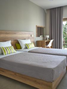1 dormitorio con 2 camas y escritorio en Grapevines Hotel, en Alikanas