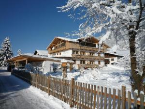 ein Haus im Schnee mit einem Zaun in der Unterkunft Haus Margreth in Sillian