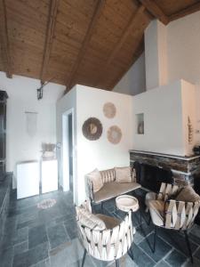 een woonkamer met een bank en stoelen en een open haard bij House Moschα in Ándros
