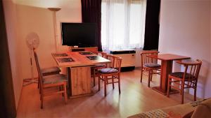 ein Wohnzimmer mit einem Tisch, Stühlen und einem TV in der Unterkunft Haus Veronika in Zamárdi