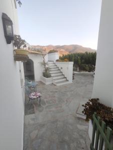 een patio met een trap en een tafel en stoelen bij House Moschα in Ándros