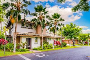 a house on a street with palm trees at Mauna Lani Resort 1401 in Waikoloa