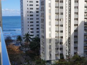 einen Blick auf zwei hohe Gebäude und das Meer in der Unterkunft Flats Capitania Varam Pitangueiras in Guarujá