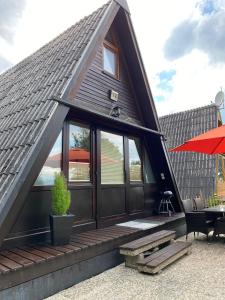 a small house with a pitched roof with a patio at Nurdachhaus am Geyersberg in Freyung