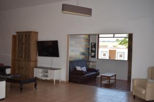 a living room with a couch and a tv at Villa Experience Heated Salty Water Pool in Caleta De Fuste