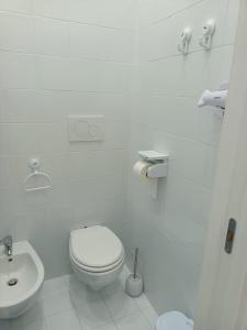 Baño blanco con aseo y lavamanos en Anna’s room en Sorrento