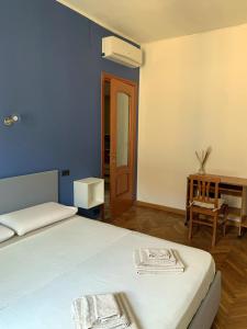 1 dormitorio con cama, mesa y escritorio en Casa Saluzzo, en Turín
