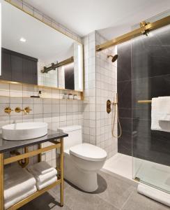 a bathroom with a toilet and a sink and a shower at Grayson Hotel in New York