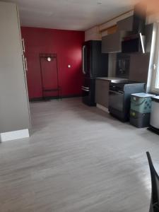 eine Küche mit roten Wänden und einer roten Tür in der Unterkunft Le Séverin : Appartement lumineux et chaleureux in Crécy-en-Ponthieu