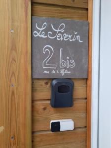 eine Tafel an einer Tür mit einem Schild darauf in der Unterkunft Le Séverin : Appartement lumineux et chaleureux in Crécy-en-Ponthieu