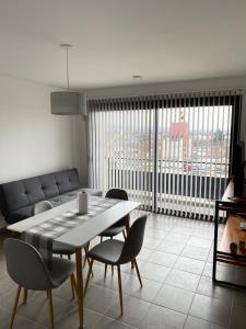 a living room with a table and chairs and a couch at Departamento Cordillera in Godoy Cruz