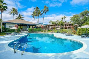 una piscina en un complejo con palmeras en Mauna Kai 5, en Princeville