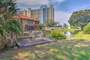 a house with a wooden deck with two chairs on it at Resort gem w/ 2-bedrooms and easy walk to beach in Panama City Beach