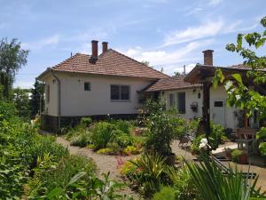 uma casa com um jardim em frente em Eperkert Vendégház em Parád