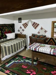 a bedroom with two beds and a table and a rug at Sunny Apart Hereditas in Ipoteşti