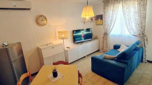 a living room with a blue couch and a tv at Bali in Abruzzo in Silvi Marina