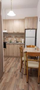 a kitchen with wooden cabinets and a table with chairs at Meteora Mandras House in Kalabaka