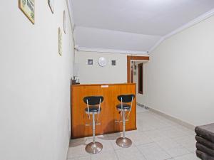 Zimmer mit zwei Barhockern und einer Theke in der Unterkunft OYO 91487 Ib Homestay Syariah in Tegal