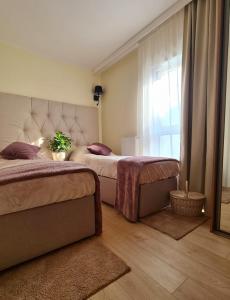 1 dormitorio con 2 camas y ventana en Malta Premium Apartment, free parking, self check-in 24h en Poznan