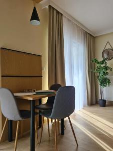 un comedor con mesa, sillas y una planta en Malta Premium Apartment, free parking, self check-in 24h, en Poznan