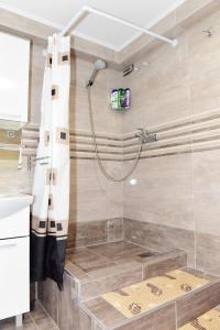 La salle de bains est pourvue d'une douche avec une porte en verre. dans l'établissement Apartman Bingo, à Josipdol