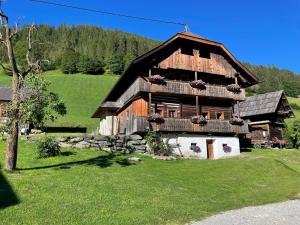 duży drewniany dom na polu trawy w obiekcie Alpenliebe w mieście Bad Kleinkirchheim