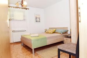 - une chambre avec un lit et une chaise dans l'établissement Apartman Bingo, à Josipdol