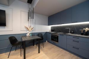 een keuken met blauwe kasten en een tafel met stoelen bij Tare apartment in Pärnu