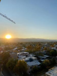 a view of a city with the sunset in the background at Departamento Cordillera in Godoy Cruz