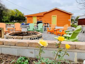a fire pit with chairs and tables in front of a cabin at EZ 1 mile to Fort Sill! Pumpkin Cottage sleeps 9, grills, firepit, laundry in Lawton