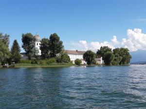 vistas a un lago con iglesia y edificio en Gästehaus Frankl en Rottau