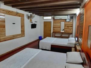 een kamer met 3 bedden en een muur met een spiegel bij Royal Cottage, Anaimalai room in Pollāchi