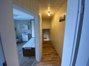 einen Flur, der zu einem Bad mit Badewanne in einem Zimmer führt in der Unterkunft Ferienwohnung Gladbeck in Gladbeck
