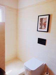 baño con aseo y una foto en la pared en Villa Al-ari en Diakopto