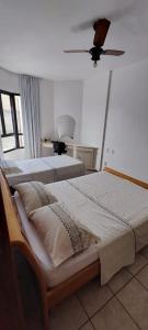 1 dormitorio con 2 camas y ventilador de techo en Apartamento Barra Tropical Residence, en Salvador