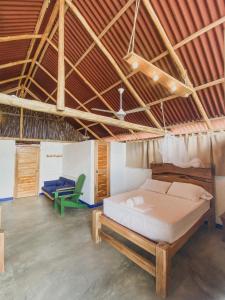 1 dormitorio con 1 cama y 1 silla verde en Mamallena Beachside Rincon del Mar, en Rincón