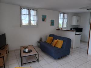 a living room with a blue couch and a table at Maison Face au Mont avec extérieur in Avranches