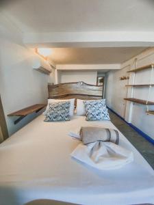 Cette chambre comprend un grand lit blanc et des étagères. dans l'établissement Mamallena Beachside Rincon del Mar, à Rincón