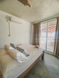 Bett in einem Zimmer mit Fenster in der Unterkunft Mamallena Beachside Rincon del Mar in Rincón