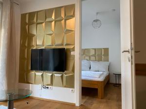 - un salon avec une télévision et une table dans l'établissement Modern apartment with garden near city center, à Vienne