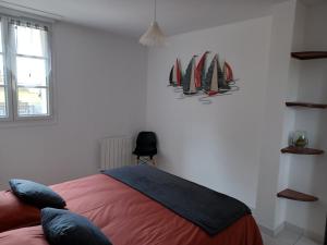 a bedroom with a bed with surfboards on the wall at Maison Face au Mont avec extérieur in Avranches