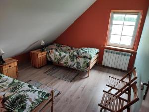 Pokój na poddaszu z łóżkiem i oknem w obiekcie Domek nad stawem 