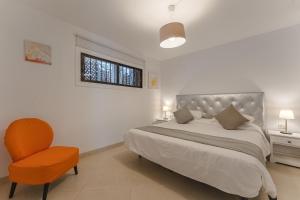 a bedroom with a bed and a chair and a window at LosCristianos Front Line of Ocean WiFi in Los Cristianos