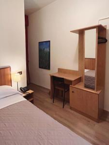a bedroom with a desk and a bed and a desk and chair at Hotel Umbria in Perugia