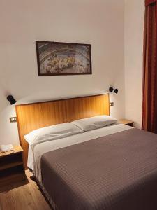 a hotel room with a bed and two lamps at Hotel Umbria in Perugia