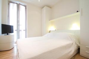 アラッシオにあるAlassio bnb Apartmentsの白いベッドルーム(ベッド1台、テレビ付)