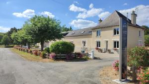 a house with a sign on the side of a road at Chambre d'Hôtes - La Rigaudière in Le Theil-de-Bretagne