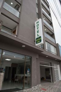 a building with a sign on the side of it at Hotel Esmeralda Verde in Teófilo Otoni