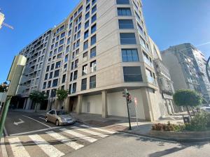 un coche está estacionado frente a un edificio alto en Move in Miragaia, en Vigo